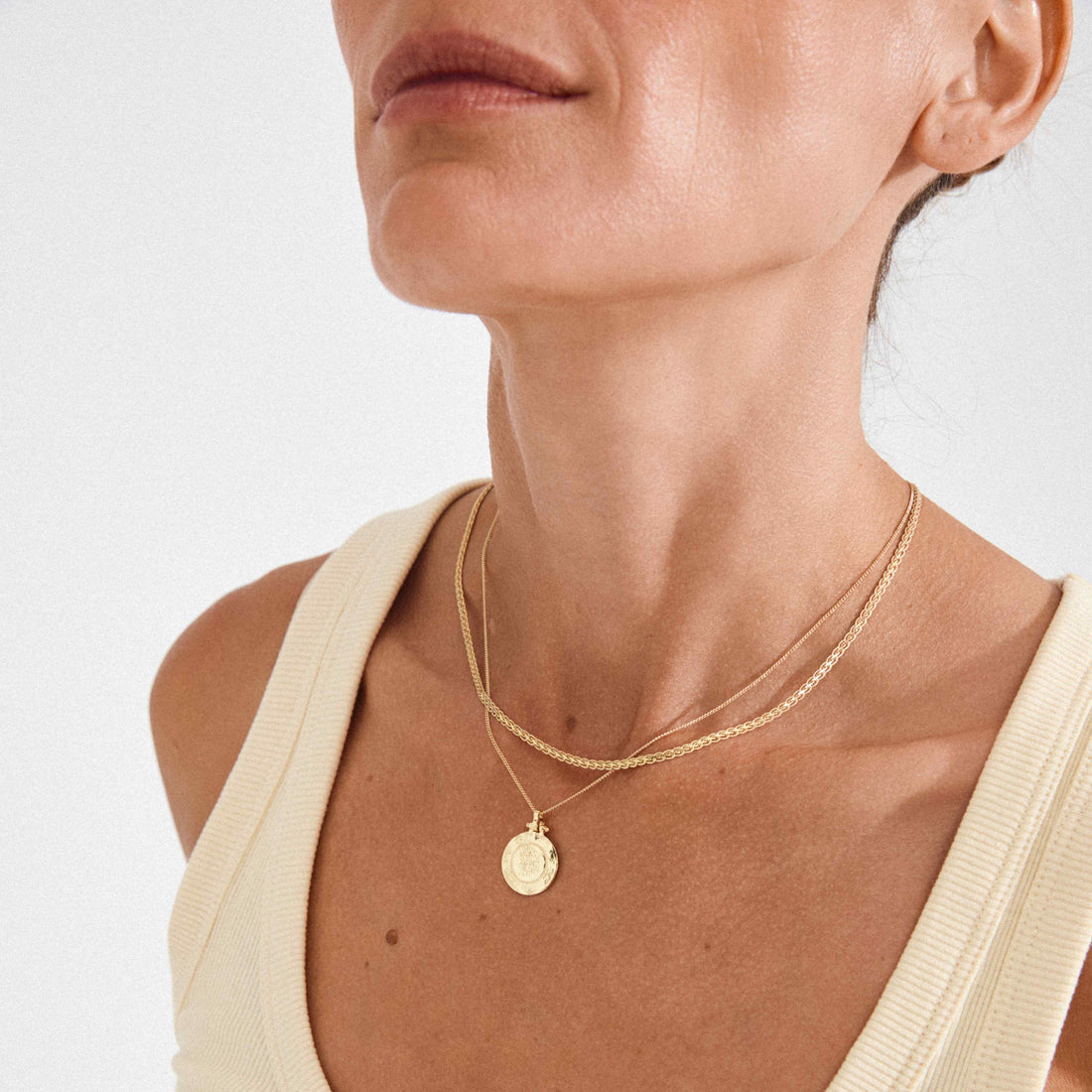Collier doré à deux chaînes et médaillon porté