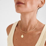 Collier doré à deux chaînes et médaillon porté