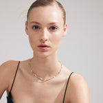 Collier doré porté avec un haut à fines bretelles