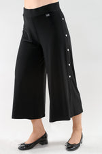 Pantalon écourté noir à jambes larges et boutons latéraux