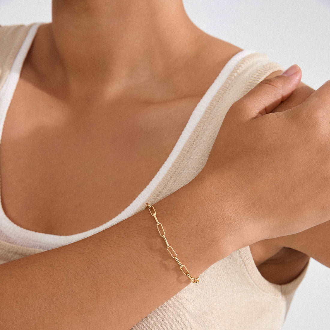 Bracelet doré à mailles porté au poignet