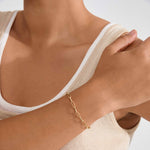 Bracelet doré à mailles porté au poignet