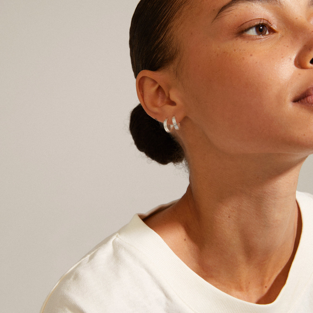 Petite boucle d’oreille argentée portée, vue de profil