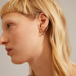 Petites boucles d’oreilles argentées portées à l’oreille