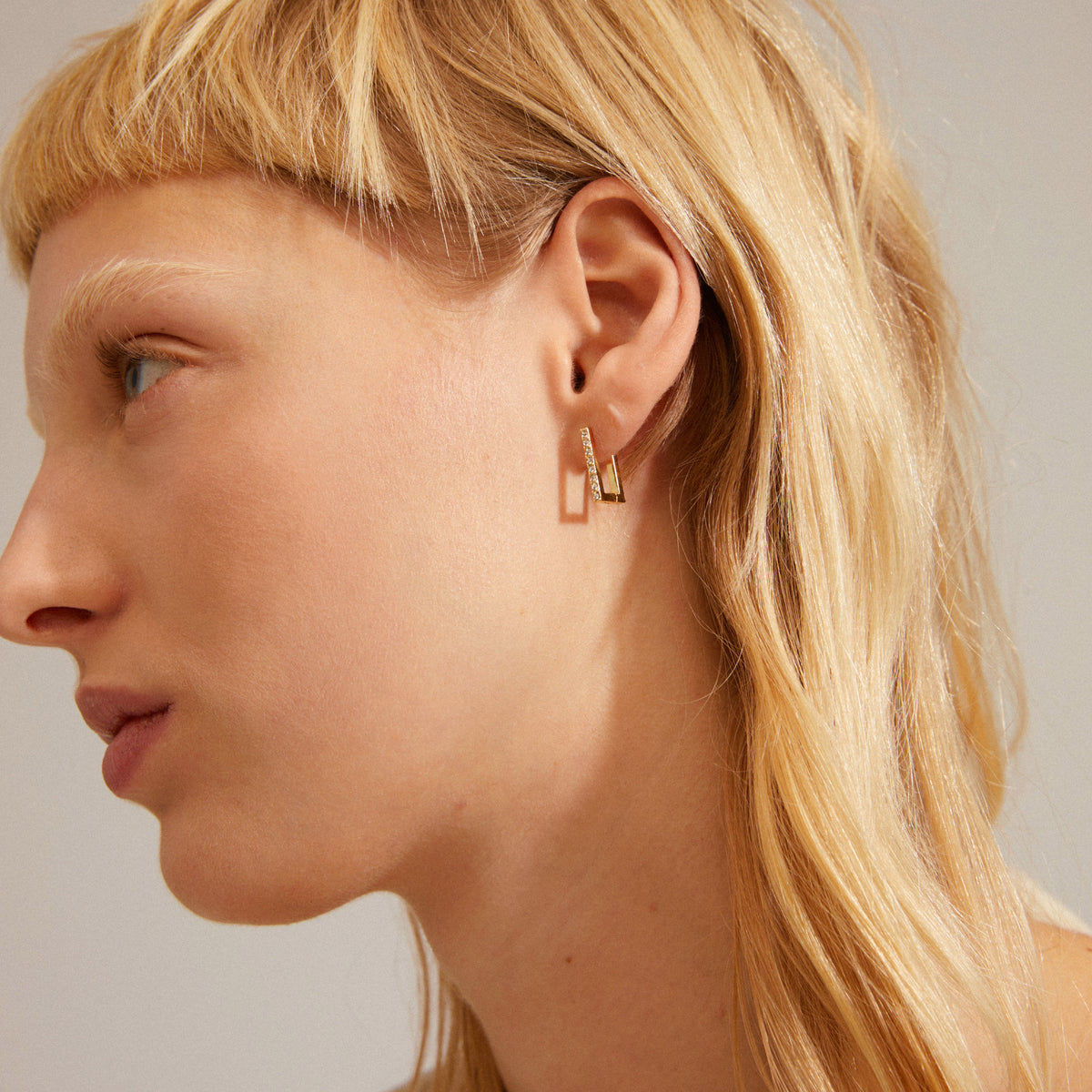 Petites boucles d’oreilles argentées portées à l’oreille