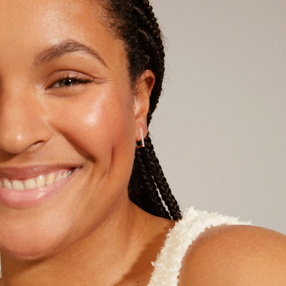 Petite boucle d’oreille dorée portée, visage souriant
