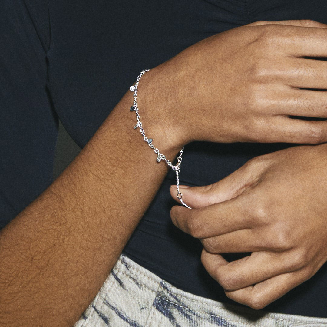 Bracelet argenté à breloques porté au poignet