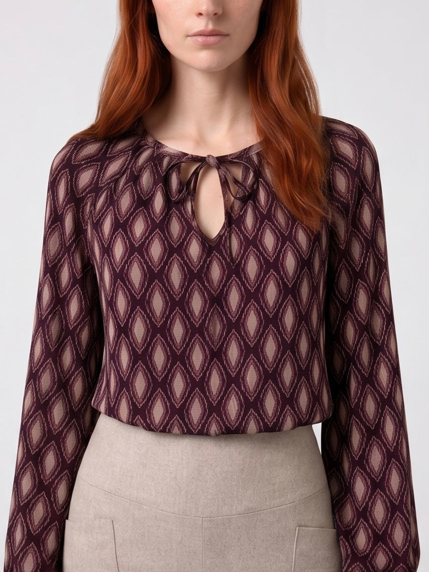 Blouse à imprimés géométriquesbordeaux avec col fendu et nouet, en viscose souple et légère.