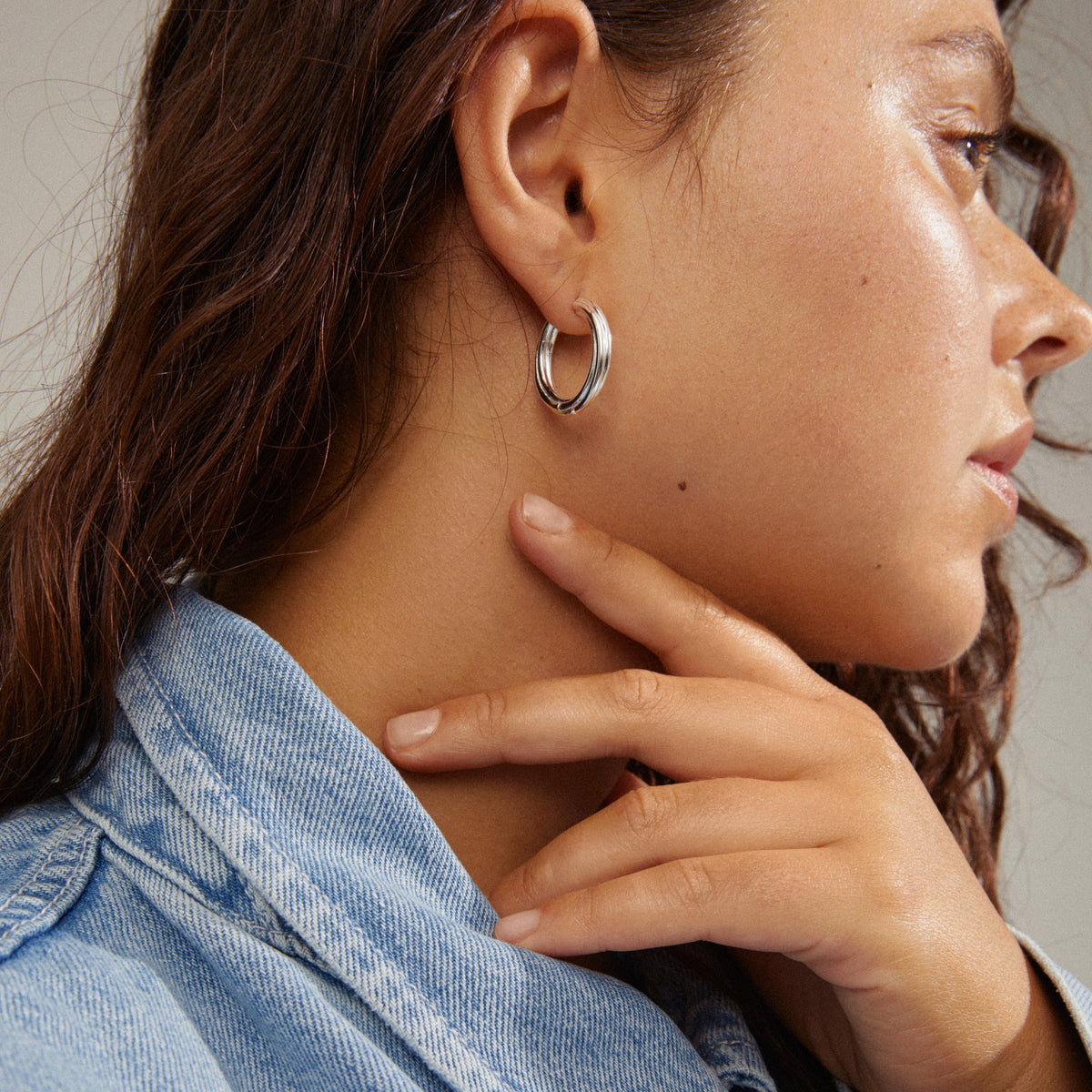 Petite créole argentée portée avec une chemise en jean