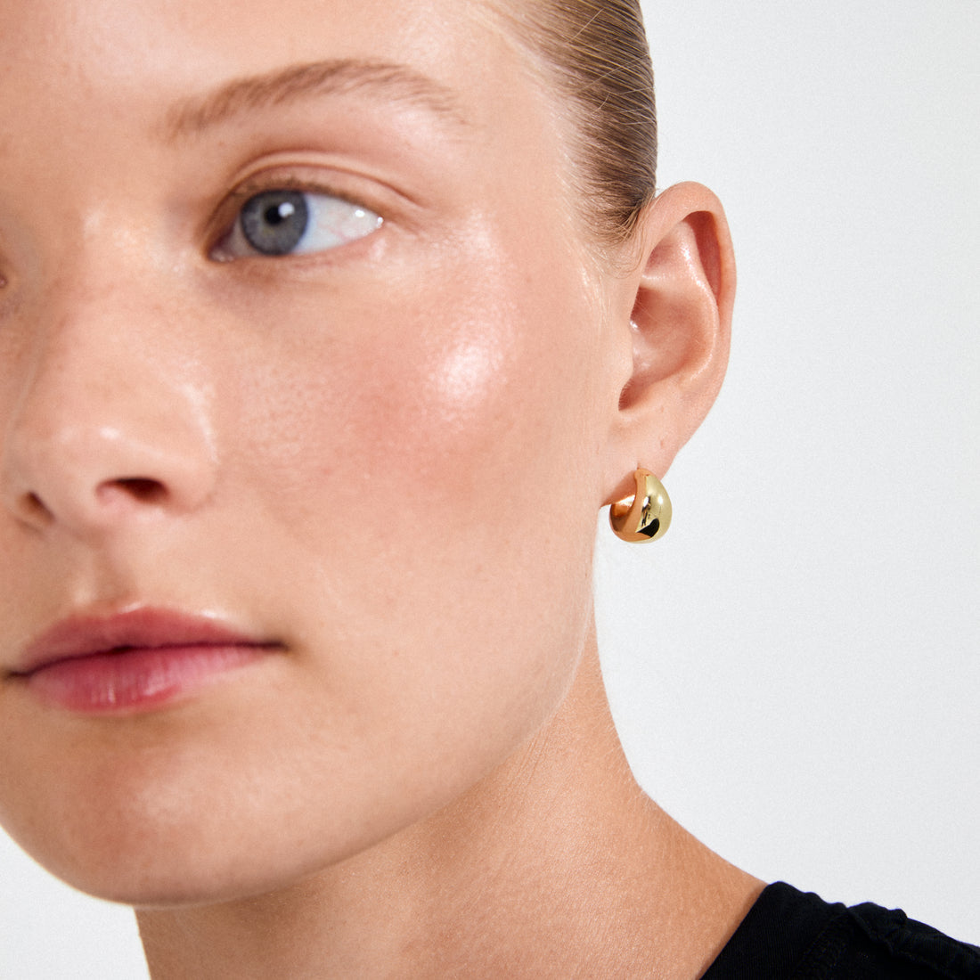Petite boucle d’oreille dorée portée