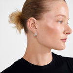 Petite boucle d’oreille argentée portée, vue de profil
