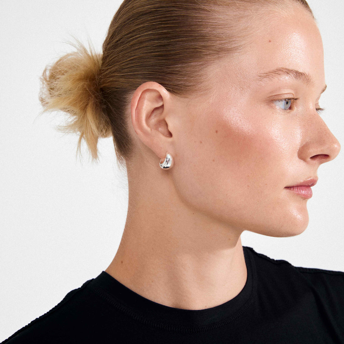 Petite boucle d’oreille argentée portée, vue de profil
