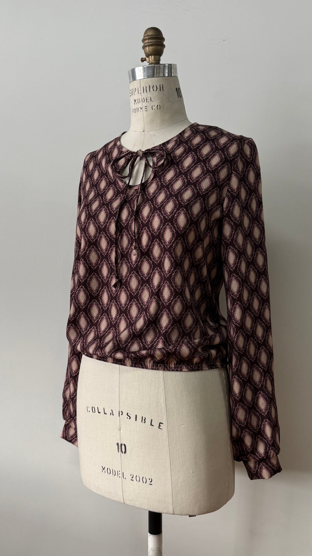 Blouse Isabella en viscose à imprimé géométrique, avec lacets au col et tombé souple.