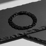 Bracelet Pilier noir AJ&co présenté sur une pierre sombre