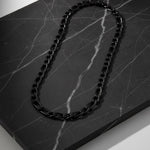 Collier Pilier noir AJ&co présenté sur un marbre sombre
