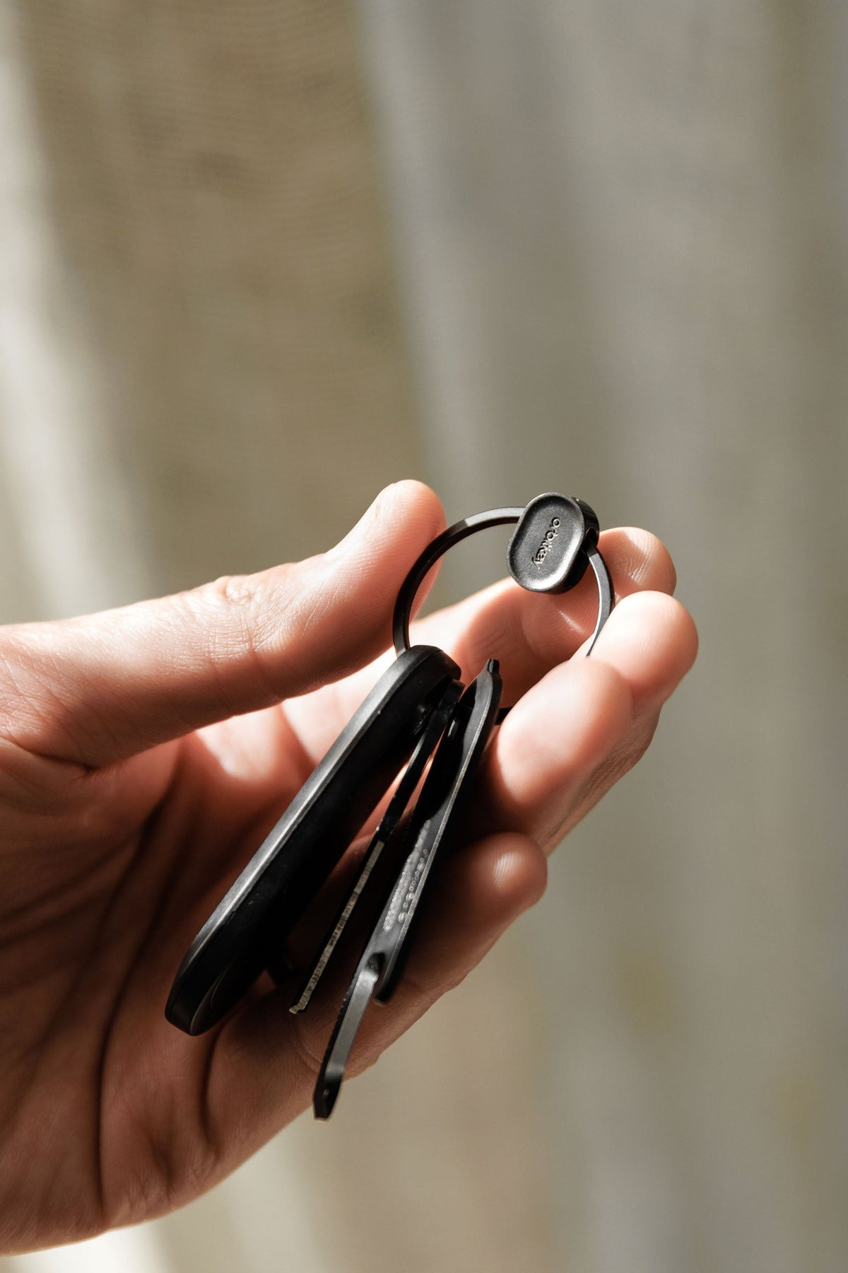 Anneau porte-clés à ouverture rapide Orbitkey Ring v2 — anneau noir tenu en main