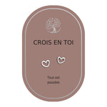 Boucles d’oreilles en cœurs argentés sur carte rose Earth Angel « Crois en toi ».