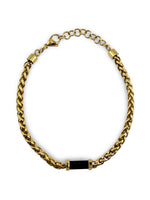 Bracelet Distingué ajustable 20–21,5 cm AJ&Co, finition dorée, avec détail noir et chaîne d’extension.