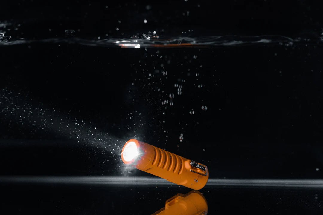 Briquet Sizzle Survival orange avec lampe allumée sous l’eau