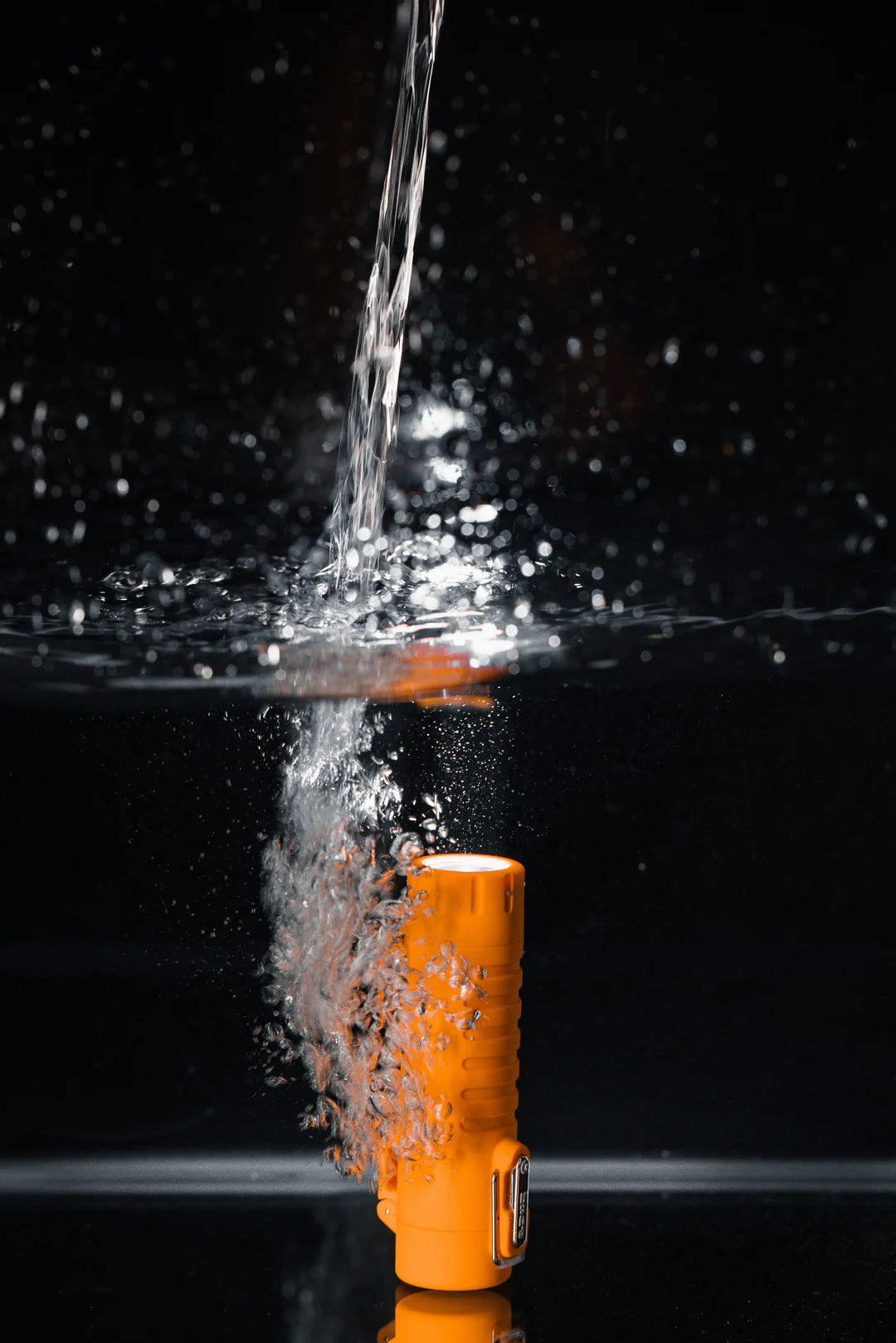 Briquet Sizzle Survival orange sous un jet d’eau