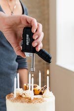 Briquet Sizzle Versa allumant les chandelles d’un gâteau