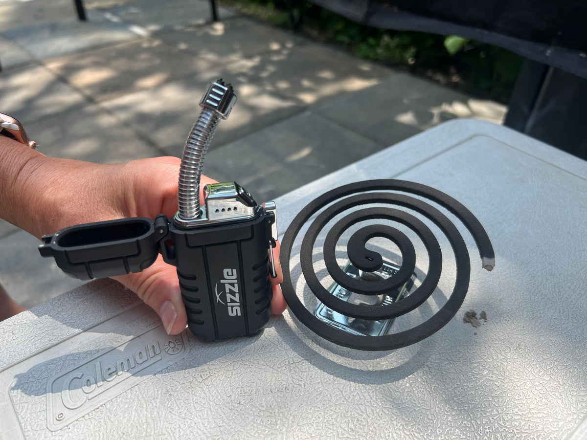 Briquet Sizzle Versa allumant une spirale antimoustiques
