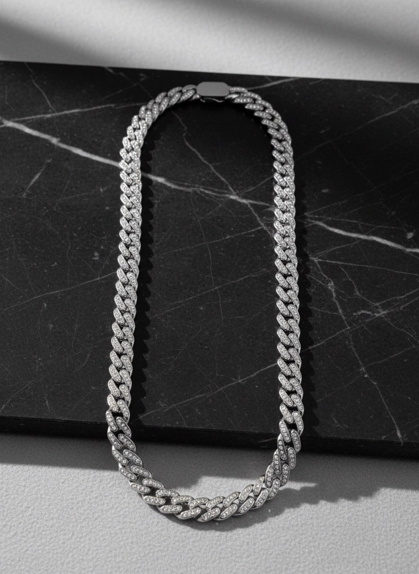 Chaîne Ambition 12 mm AJ&Co, finition argentée, chaîne à zircons présentée sur un support en marbre.