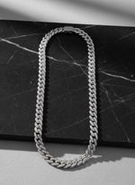 Chaîne Ambition 12 mm AJ&Co, finition argentée, chaîne à zircons présentée sur un support en marbre.