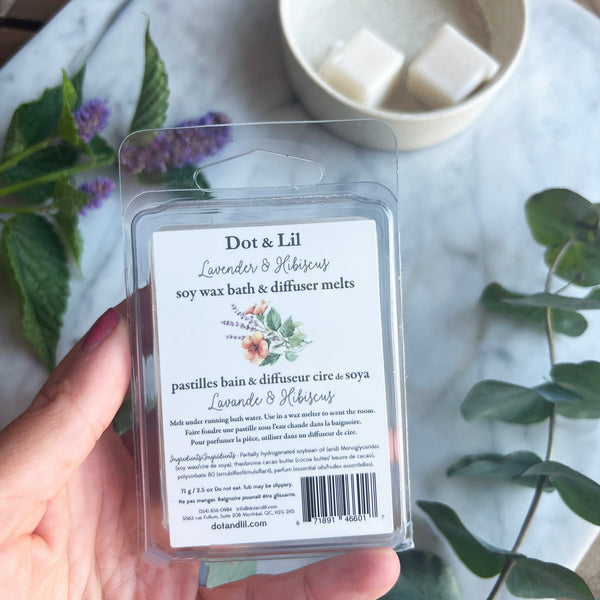 Dos d’un emballage de pastilles de cire Dot & Lil tenu dans une main