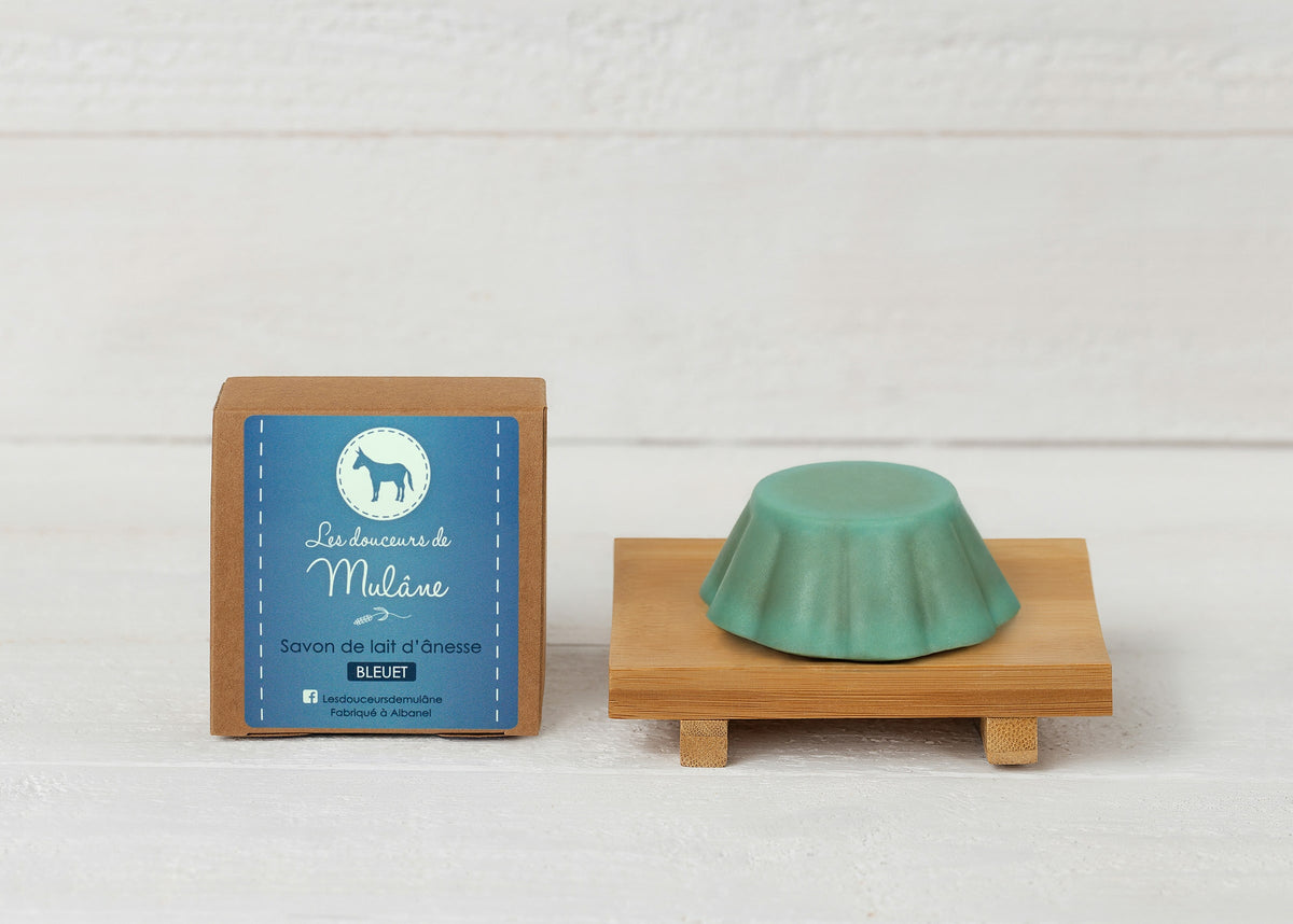 Savon exfoliant au bleuet Mulâne avec sa boîte bleue et un porte-savon en bois
