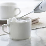Fouet du mousseur Trudeau au-dessus d’une tasse de lait mousseux