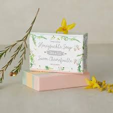 Savon rose Dot & Lil près de fleurs jaunes