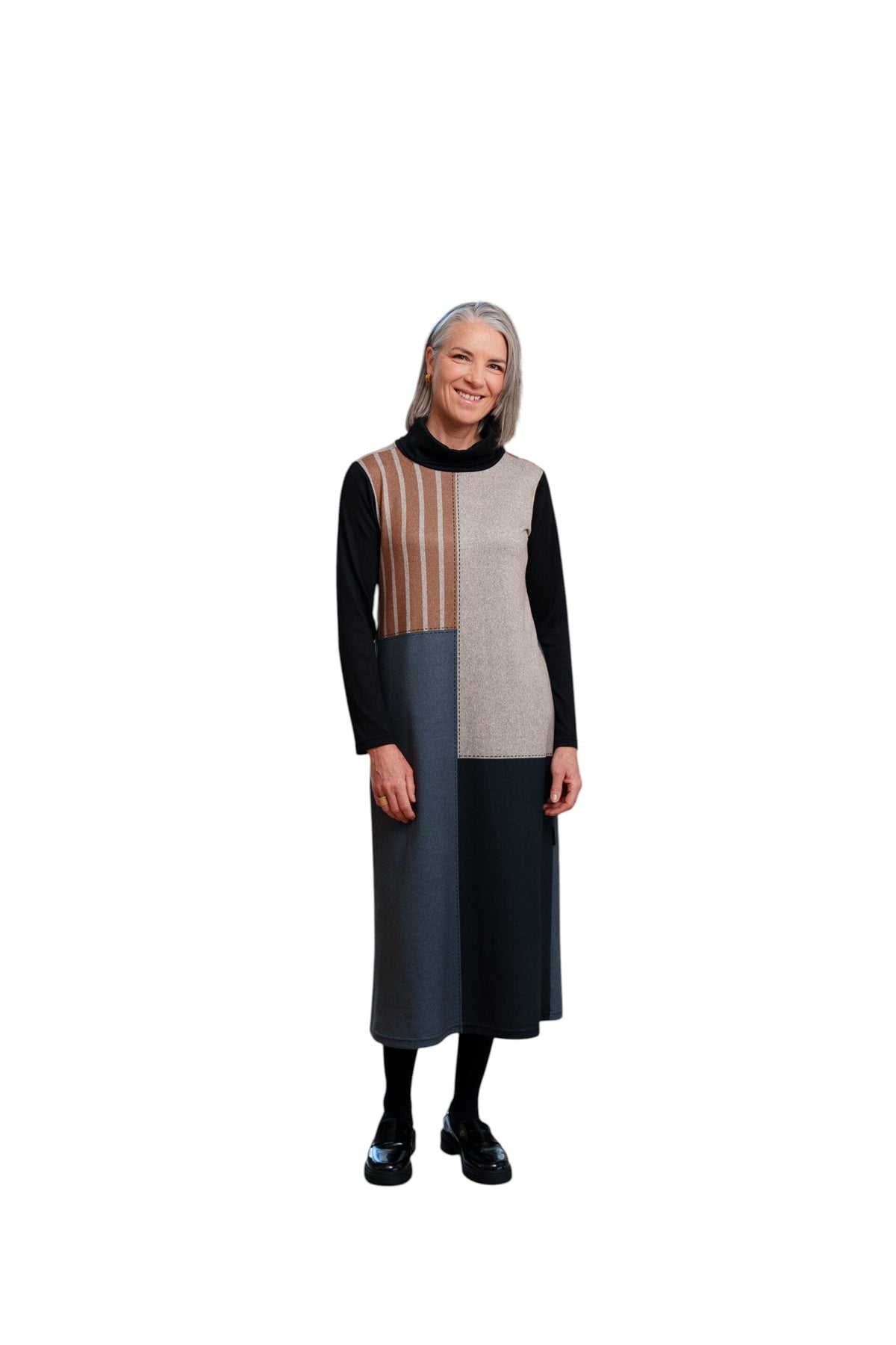 Femme souriante portant la robe 7/8 La Maison du Bleuet noire et rayée à col roulé et découpes asymétriques
