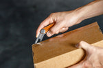 Outil multifonction Multi-Tool v2 Orbitkey — utilisé pour ouvrir un carton