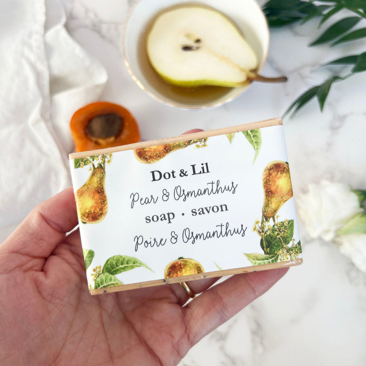 Savon Poire et Osmanthus de Dot & Lil tenu dans une main