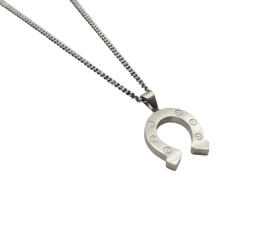 Pendentif fer à cheval Indomptable AJ&Co, finition argentée mate, pendentif vu en biais.