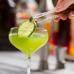 Pince de bar Final Touch déposant une tranche de lime sur un cocktail.