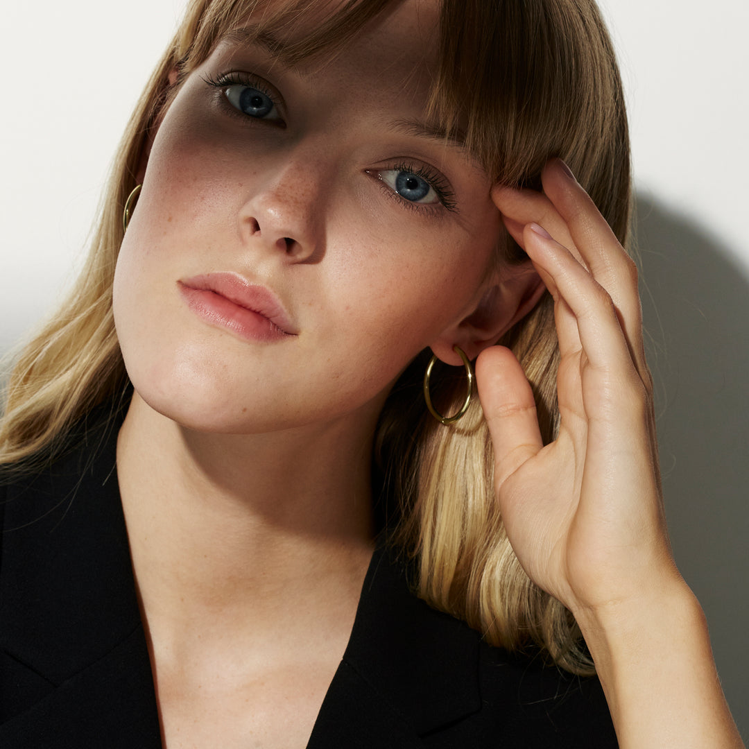 Boucles d’oreilles pendantes portées avec une veste noire