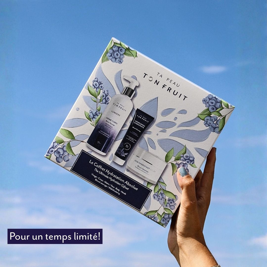 Coffret Hydratation absolue de Ta peau, ton fruit tenu à la main devant un ciel bleu