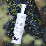 Lait démaquillant Pureté posé parmi des bleuets — Ta peau, ton fruit