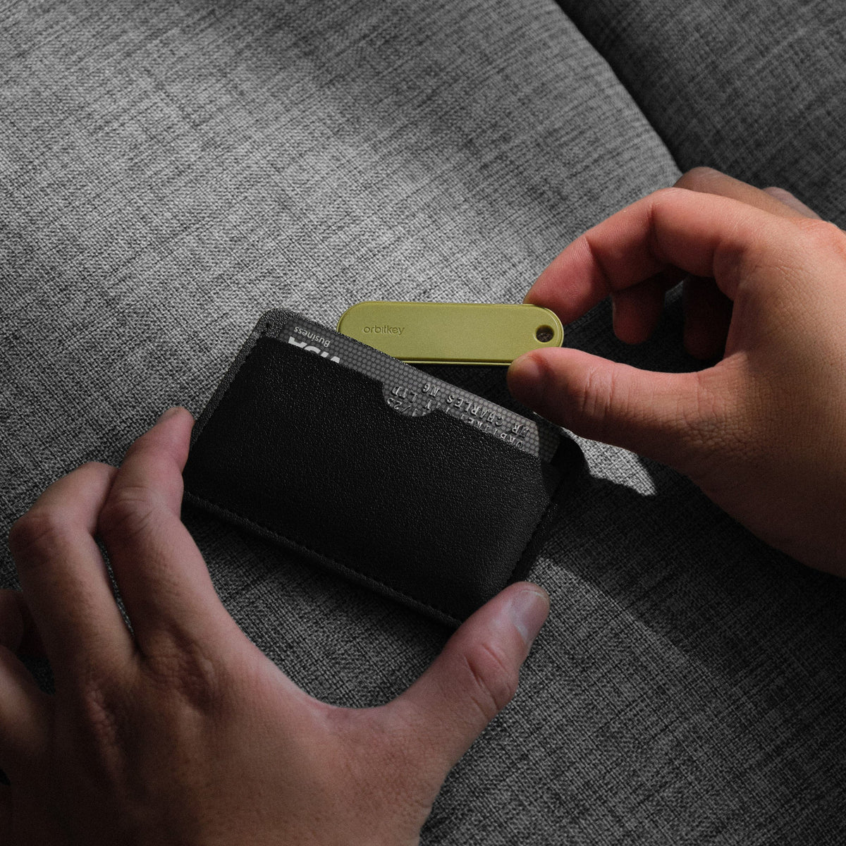 Traceur universel Orbitkey — traceur glissé dans un portefeuille